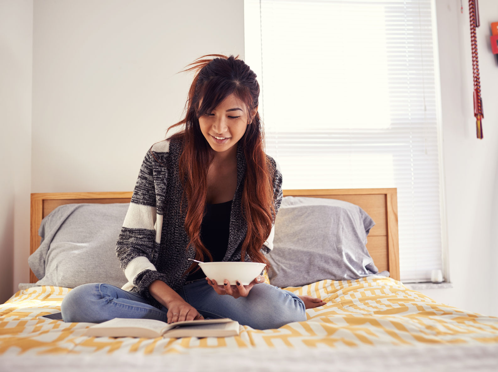 Young lady reading on a bed for get caught reading month
