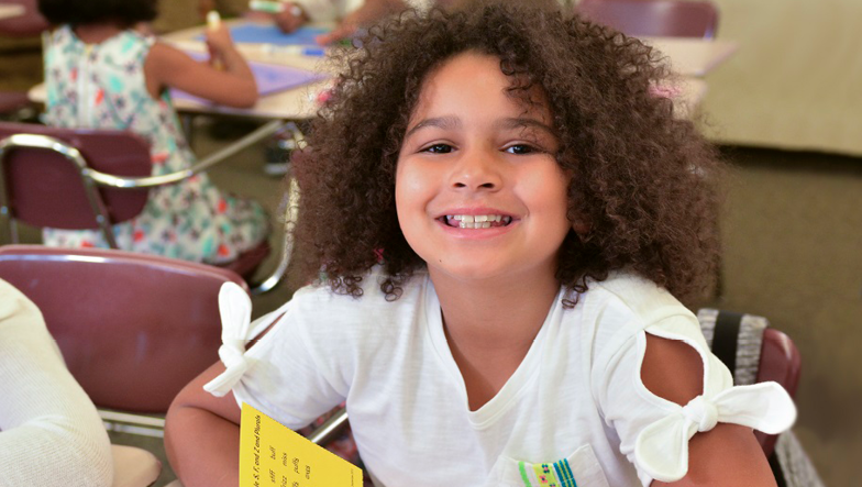 young girl holding transfer cards and smiling