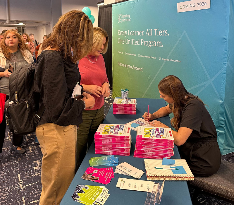 Lindsay Kemeny signing a book at the Reading Horizons booth at The Reading League 2025 conference